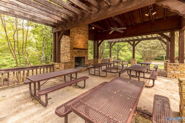 view of patio featuring ceiling fan and an outdoor stone fireplace