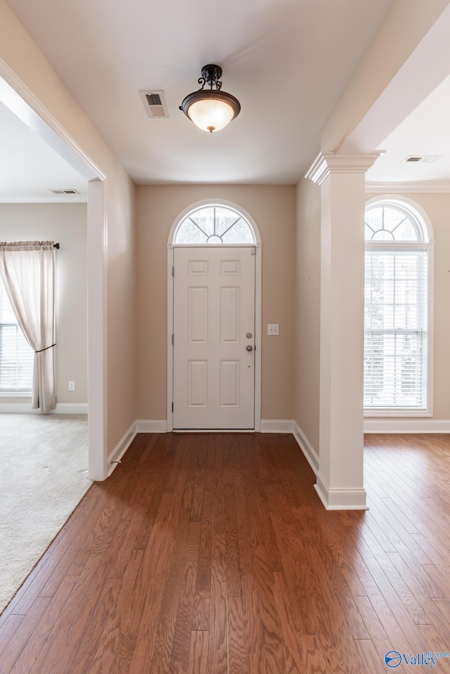 foyer entrance with decorative columns and dark wood-type flooring