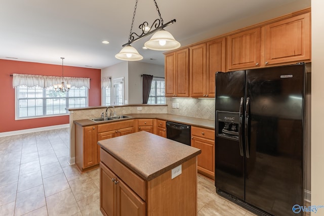 kitchen featuring a healthy amount of sunlight, black appliances, a center island, and hanging light fixtures