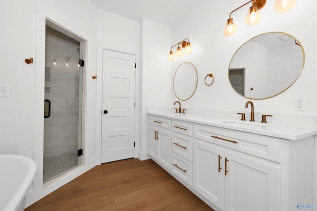 bathroom with hardwood / wood-style flooring, vanity, and shower with separate bathtub