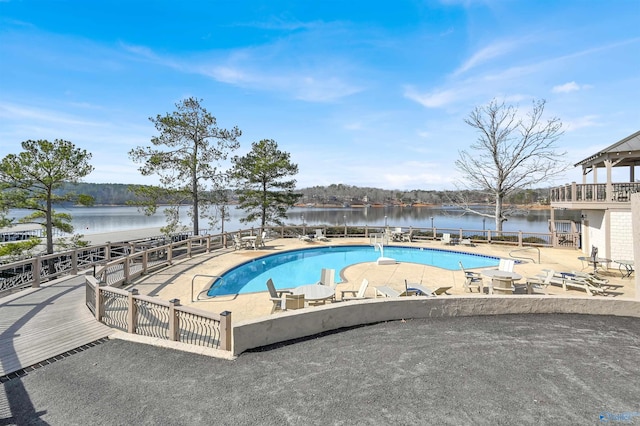 view of pool with a patio and a water view