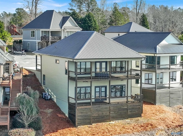 rear view of property featuring a balcony and central AC unit