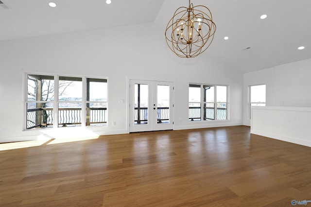 unfurnished living room featuring french doors, dark hardwood / wood-style floors, high vaulted ceiling, and a notable chandelier