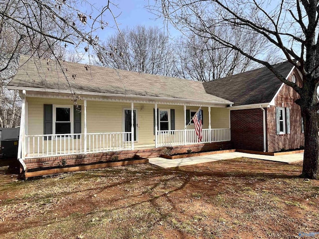 single story home with a porch and brick siding