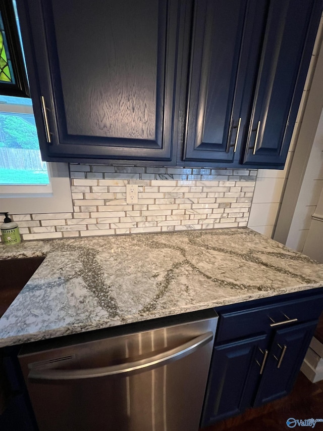 kitchen featuring blue cabinets, light stone countertops, tasteful backsplash, and stainless steel dishwasher