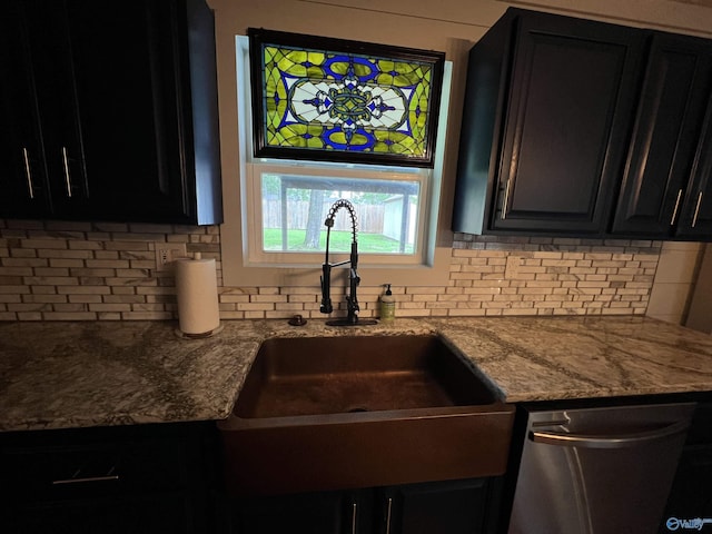 kitchen with dark cabinets, dishwasher, backsplash, and a sink