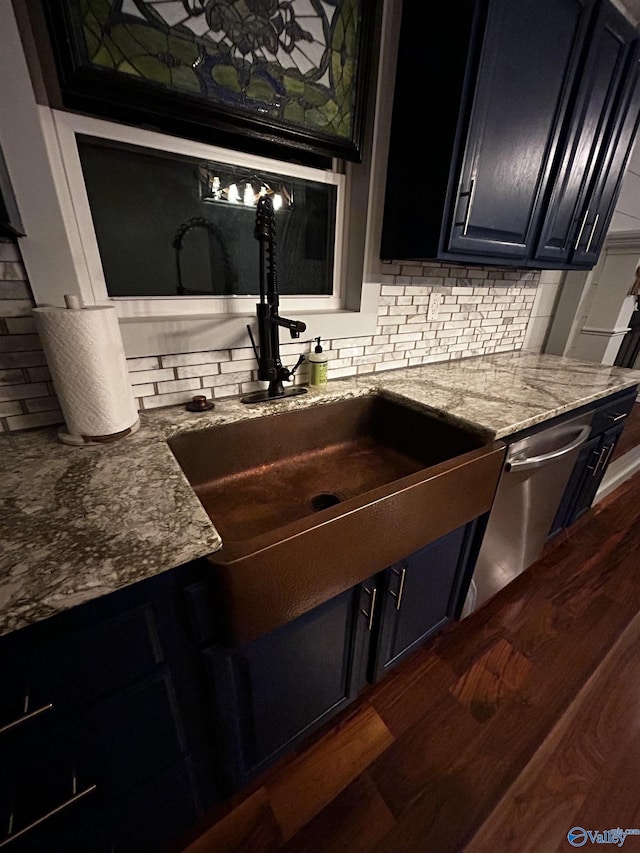 kitchen featuring a sink, dishwasher, dark wood finished floors, and backsplash