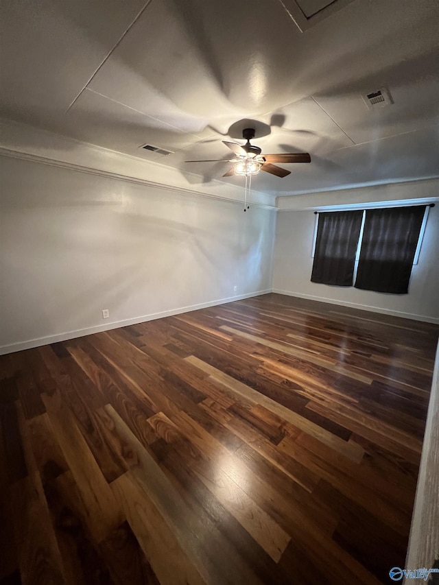 empty room with dark wood-style floors, baseboards, and visible vents