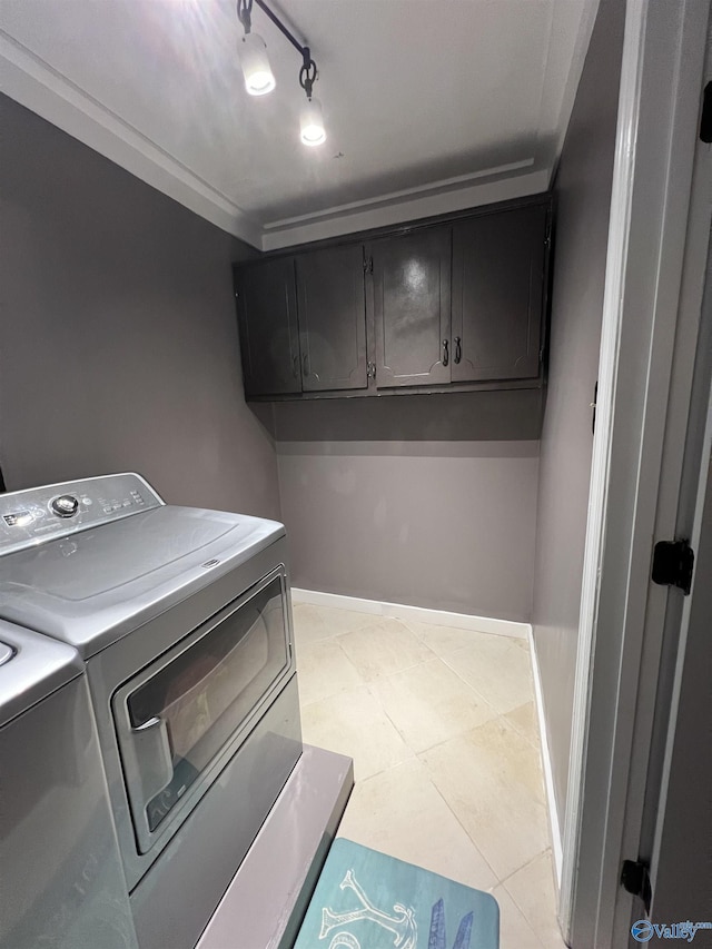 laundry area featuring cabinet space, light tile patterned floors, baseboards, independent washer and dryer, and track lighting