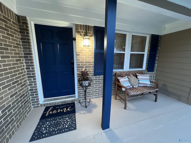 doorway to property featuring brick siding