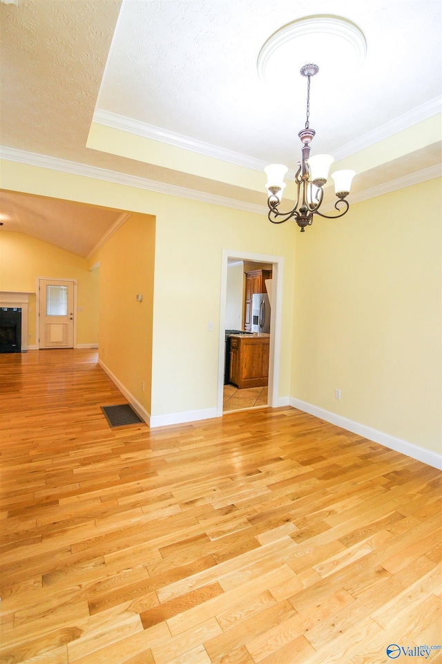 interior space with ornamental molding, an inviting chandelier, light hardwood / wood-style floors, and a textured ceiling