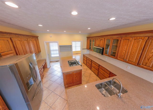 kitchen featuring light tile patterned floors, stainless steel appliances, a textured ceiling, crown molding, and sink