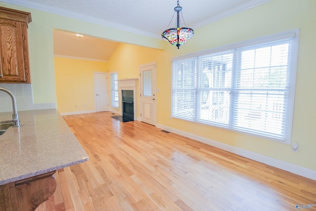 kitchen featuring light hardwood / wood-style flooring, plenty of natural light, and ornamental molding