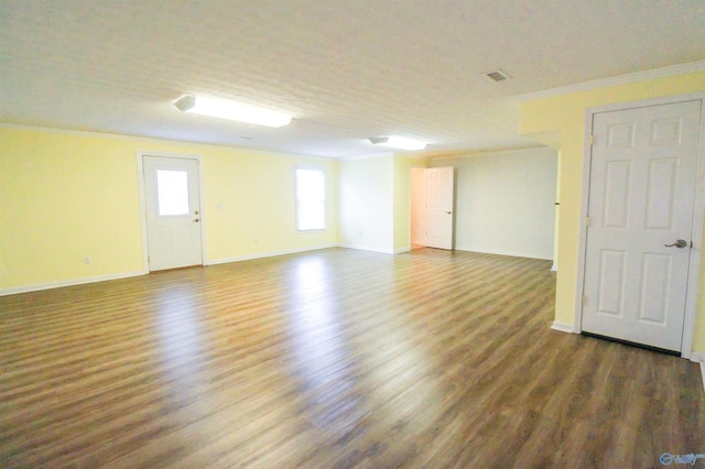 unfurnished room featuring a textured ceiling, dark hardwood / wood-style floors, and crown molding