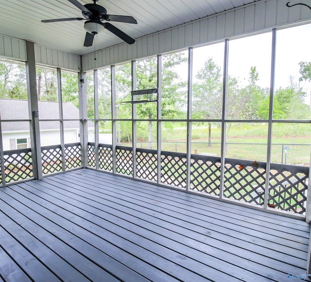 unfurnished sunroom featuring ceiling fan and a wealth of natural light