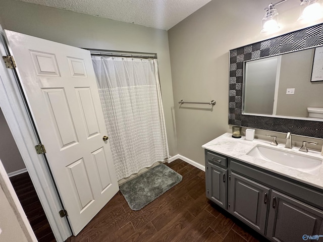 535 10th St NW, Arab, AL 35016 - full bath featuring wood finished floors, vanity, a textured ceiling, baseboards, and a shower with curtain