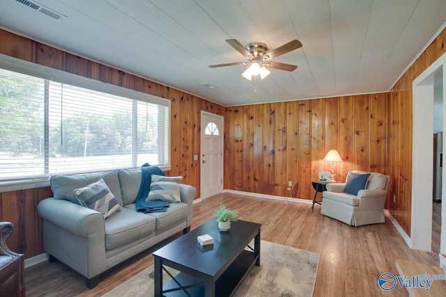 7615 Scottsboro Hwy, Scottsboro, AL 35769 - living room featuring wooden walls, a ceiling fan, visible vents, baseboards, and wood finished floors