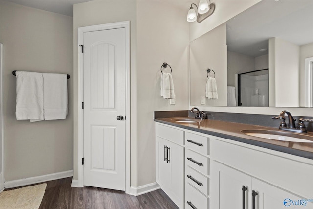 bathroom featuring walk in shower, double sink vanity, and hardwood / wood-style floors