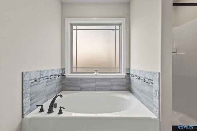 bathroom with a healthy amount of sunlight and a tub to relax in