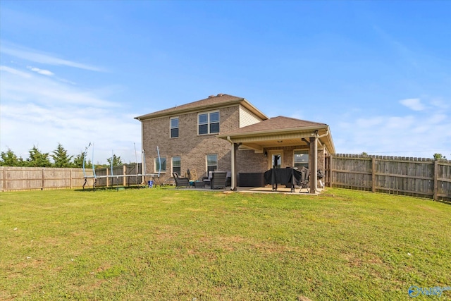 rear view of house with a patio area and a lawn