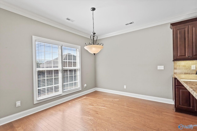 unfurnished dining area with baseboards, visible vents, and light wood finished floors