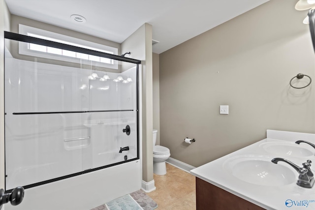 full bathroom featuring toilet, bath / shower combo with glass door, a sink, and tile patterned floors