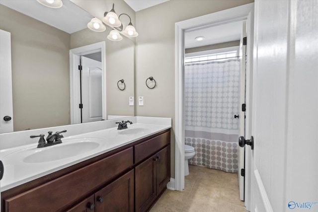 bathroom featuring tile patterned floors, a sink, toilet, and double vanity