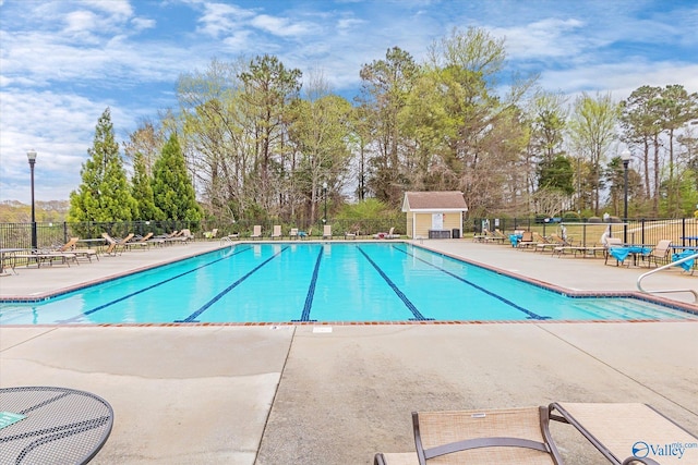 community pool with fence and a patio