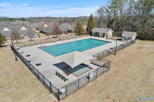 community pool featuring a patio, an outdoor structure, and fence