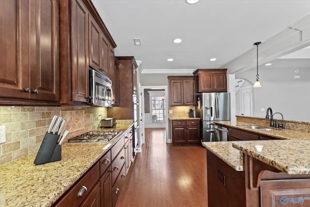 kitchen featuring dark wood-style floors, appliances with stainless steel finishes, light stone counters, and crown molding