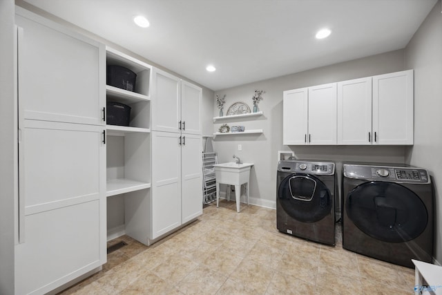 laundry room featuring baseboards, recessed lighting, cabinet space, a sink, and washer and dryer