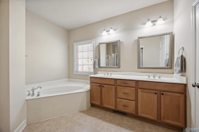 bathroom with a sink, double vanity, a bath, and tile patterned floors