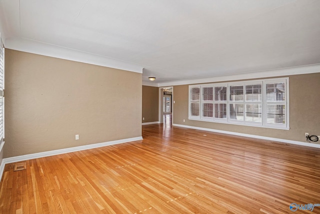 empty room featuring light wood-style flooring, baseboards, and visible vents