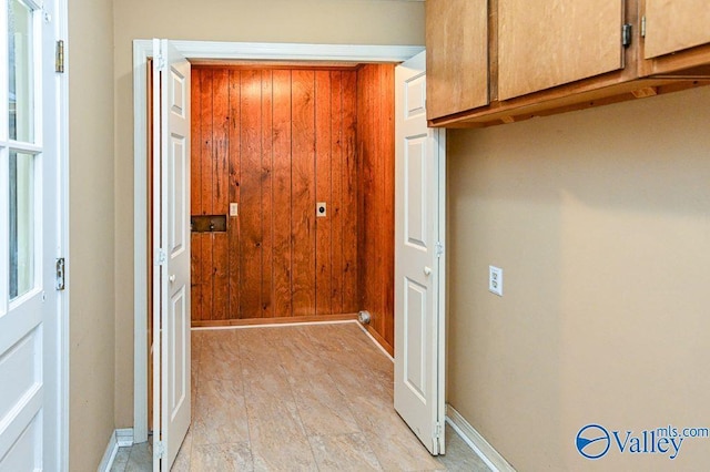 doorway with wood walls and baseboards