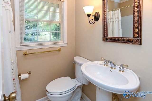 full bath featuring baseboards, a sink, a shower with shower curtain, and toilet