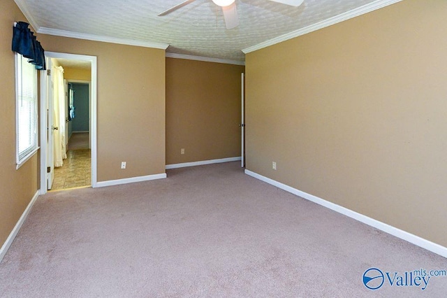 unfurnished bedroom featuring baseboards, a ceiling fan, carpet flooring, and crown molding