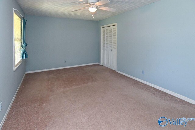 spare room featuring baseboards, carpet, and ceiling fan