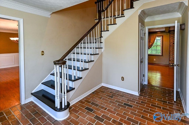 stairway with brick floor, baseboards, a chandelier, and ornamental molding
