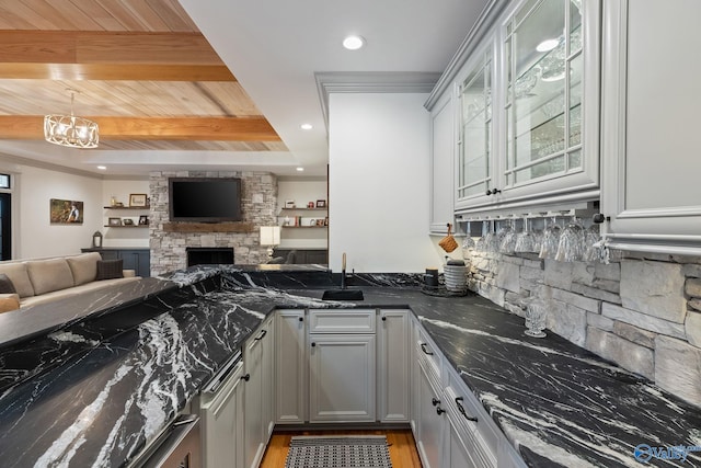 kitchen with dark stone counters, gray cabinetry, decorative backsplash, wood ceiling, and beam ceiling