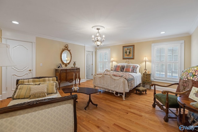 bedroom featuring ornamental molding, light wood-type flooring, and an inviting chandelier