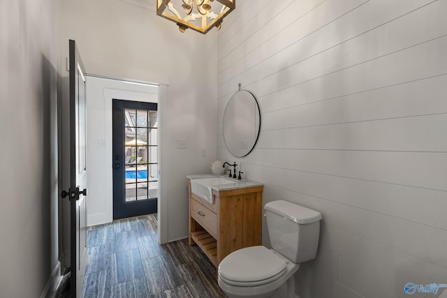 bathroom with toilet, vanity, and wood-type flooring