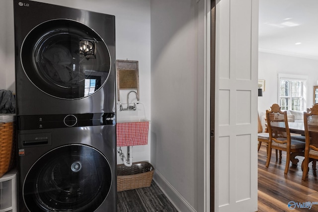 washroom with stacked washer and dryer and hardwood / wood-style floors