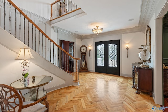 entryway featuring french doors, crown molding, and light parquet floors