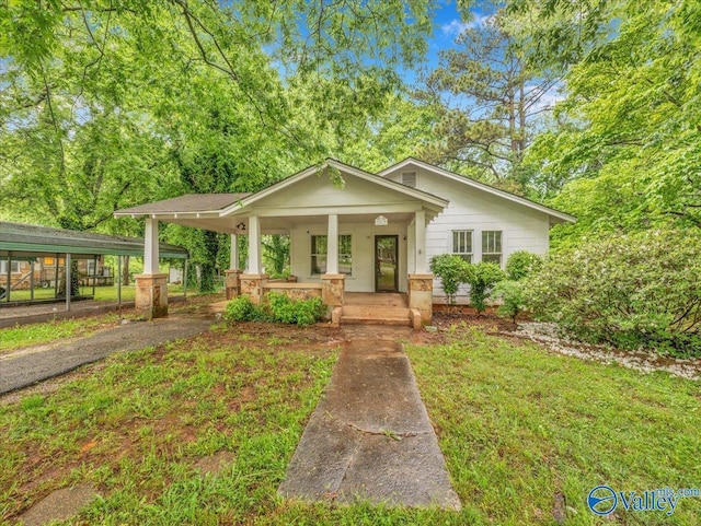 bungalow-style home with covered porch and aphalt driveway