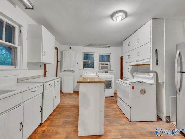 kitchen featuring light wood-style flooring, white cabinets, freestanding refrigerator, white electric range, and separate washer and dryer