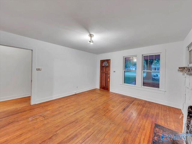 spare room featuring light wood finished floors and baseboards