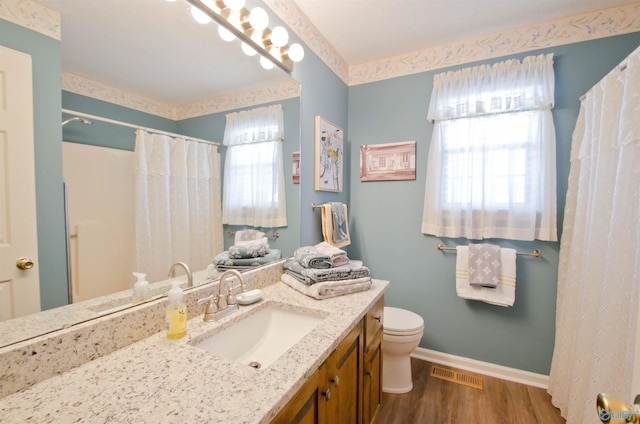 bathroom featuring vanity, hardwood / wood-style floors, a wealth of natural light, and toilet