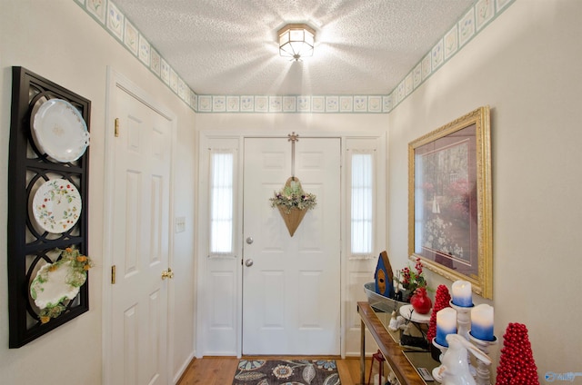 entrance foyer featuring plenty of natural light, hardwood / wood-style floors, and a textured ceiling