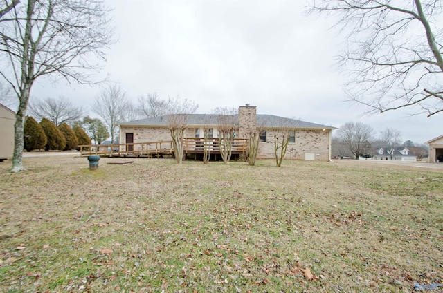 rear view of property with a wooden deck and a yard