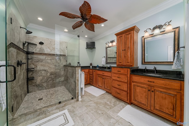 bathroom with vanity, a shower with shower door, and ornamental molding